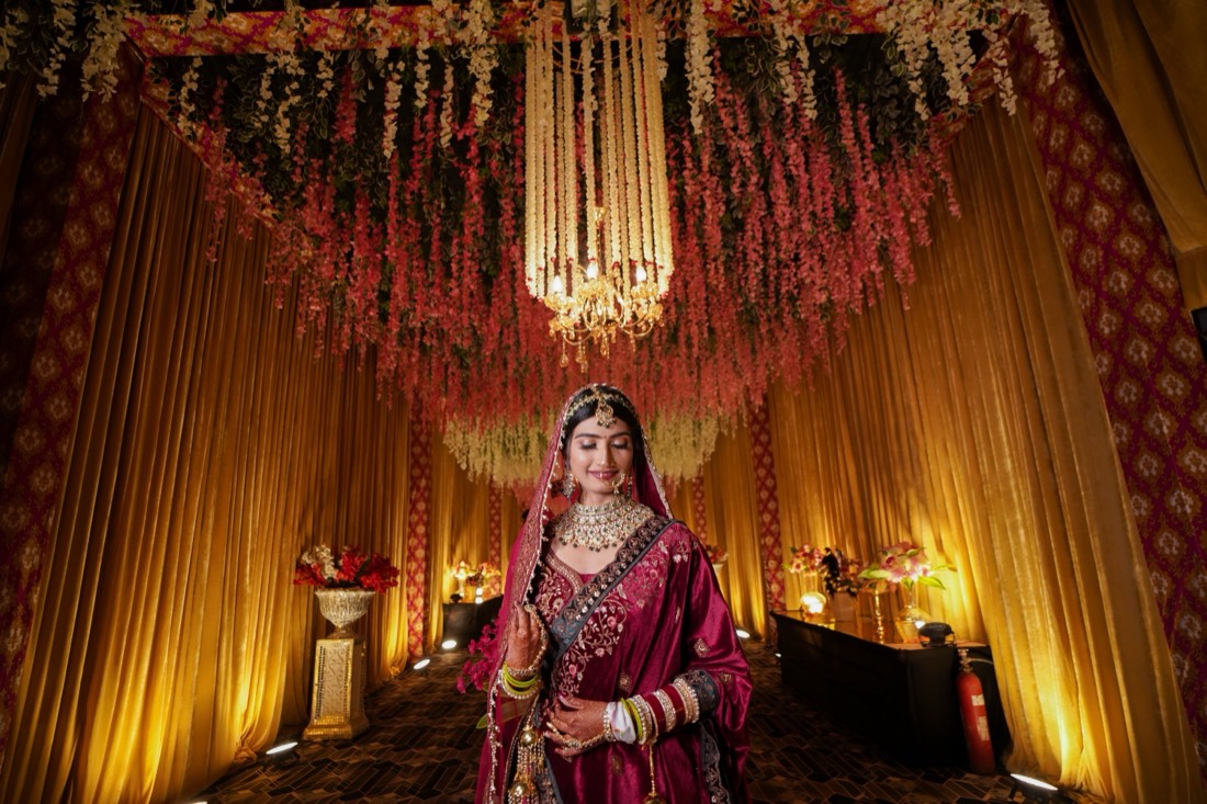 Bride under a floral and fairy light installation styled by SGR Decorators