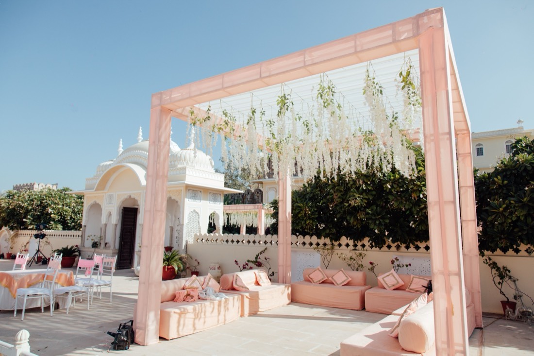 White floral stage backdrop with pastel lounge seating by SGR Decorators